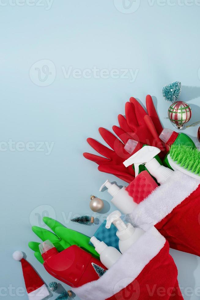 Christmas cleaning. Cleaning tools and Christmas decorations top view flat lay on blue background with copy space photo