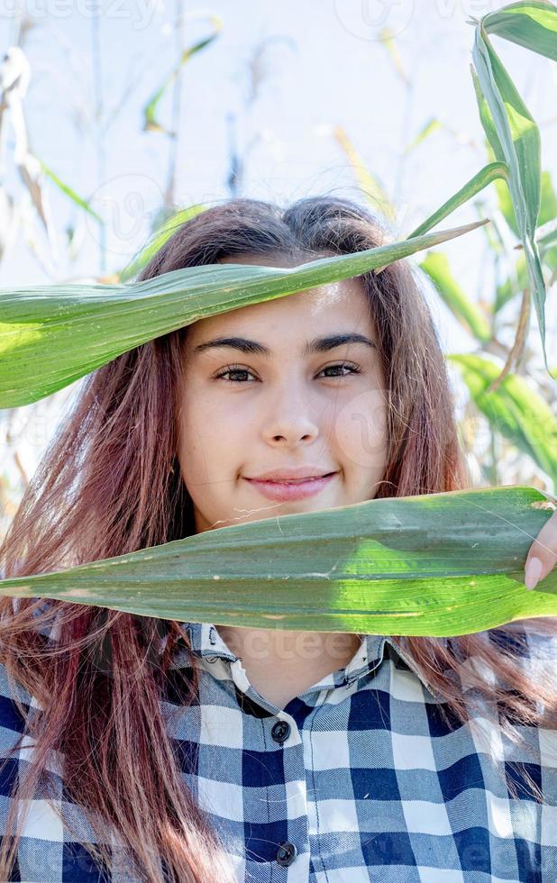 primer plano de una mujer caucásica que cubre la cara con hojas de maíz foto