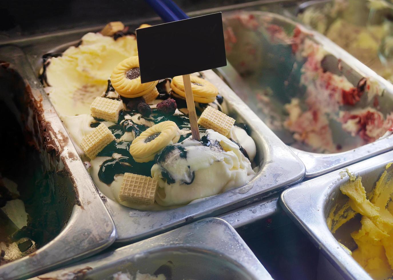 Close up Blueberry Cheesecake flavored and other flavors of gelato ice cream among empty tray at the showcase in homemade ice cream shop photo