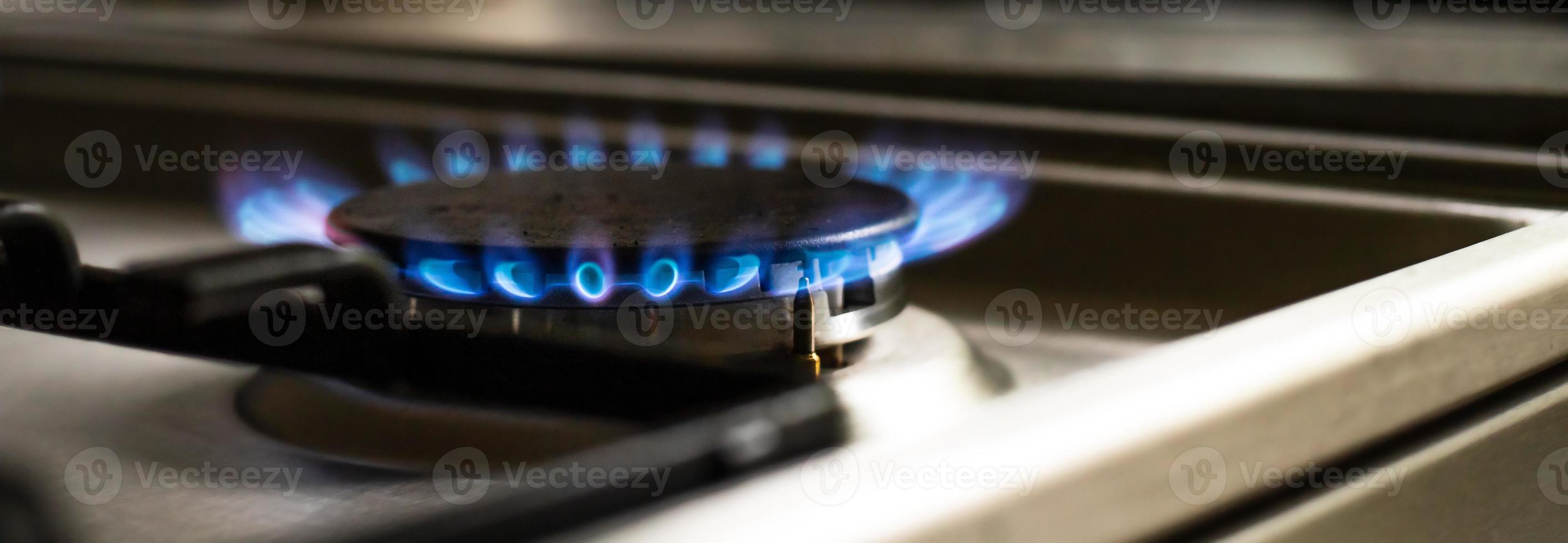 Close-up of a blue fire from a kitchen stove. two gas burners with a burning flame. economy concept.wide baner photo