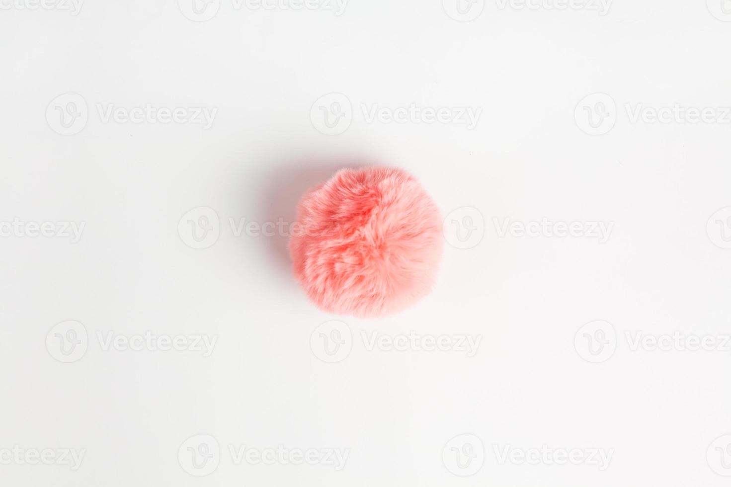 Coral fluffy fur ball on white background photo
