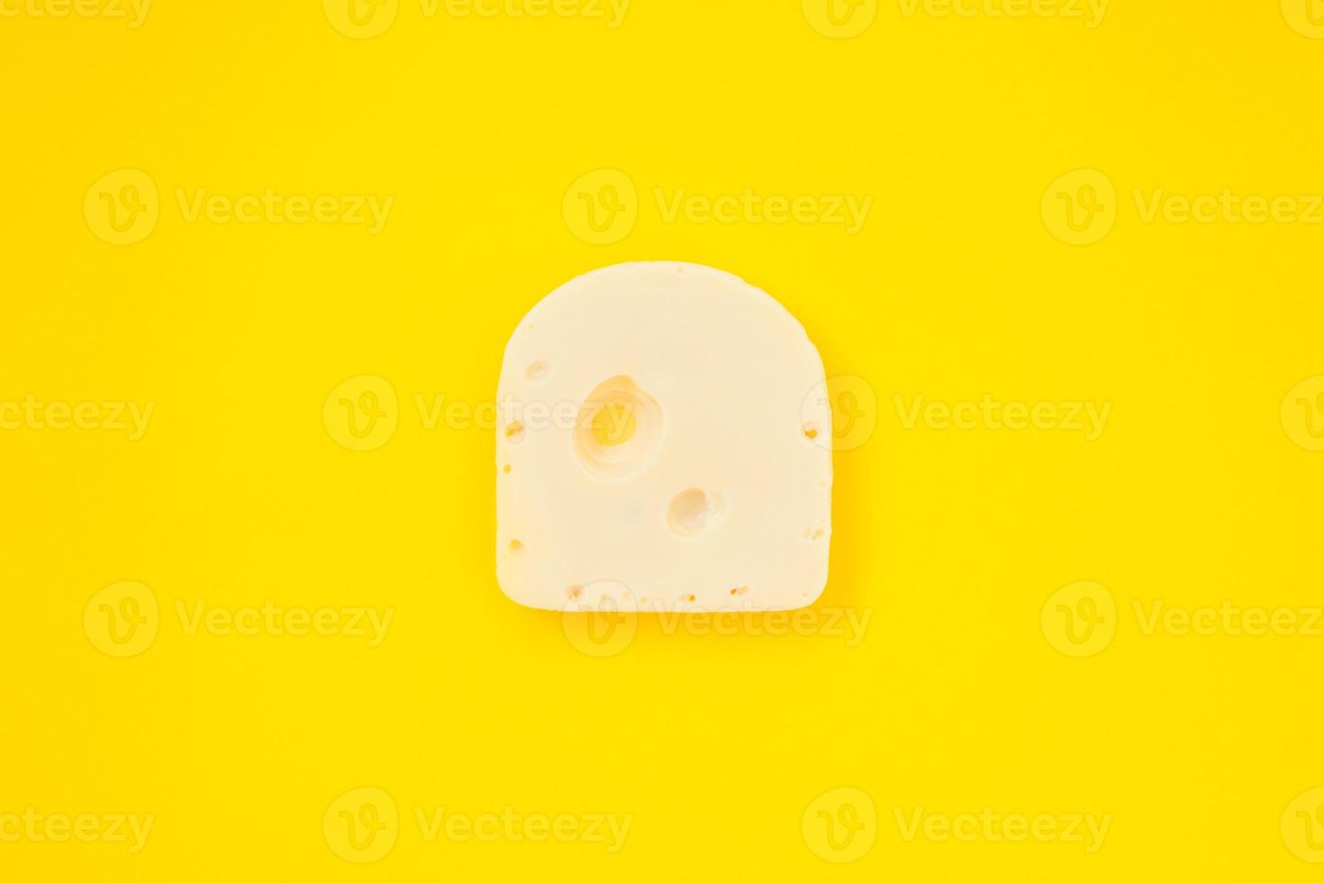 Piece of cheese on yellow color background photo