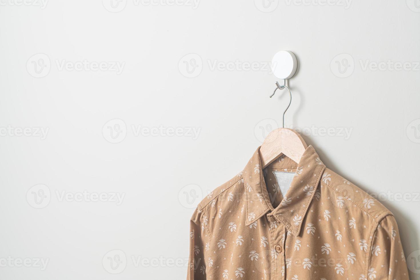 hanging shirt with wood hanger on wall photo