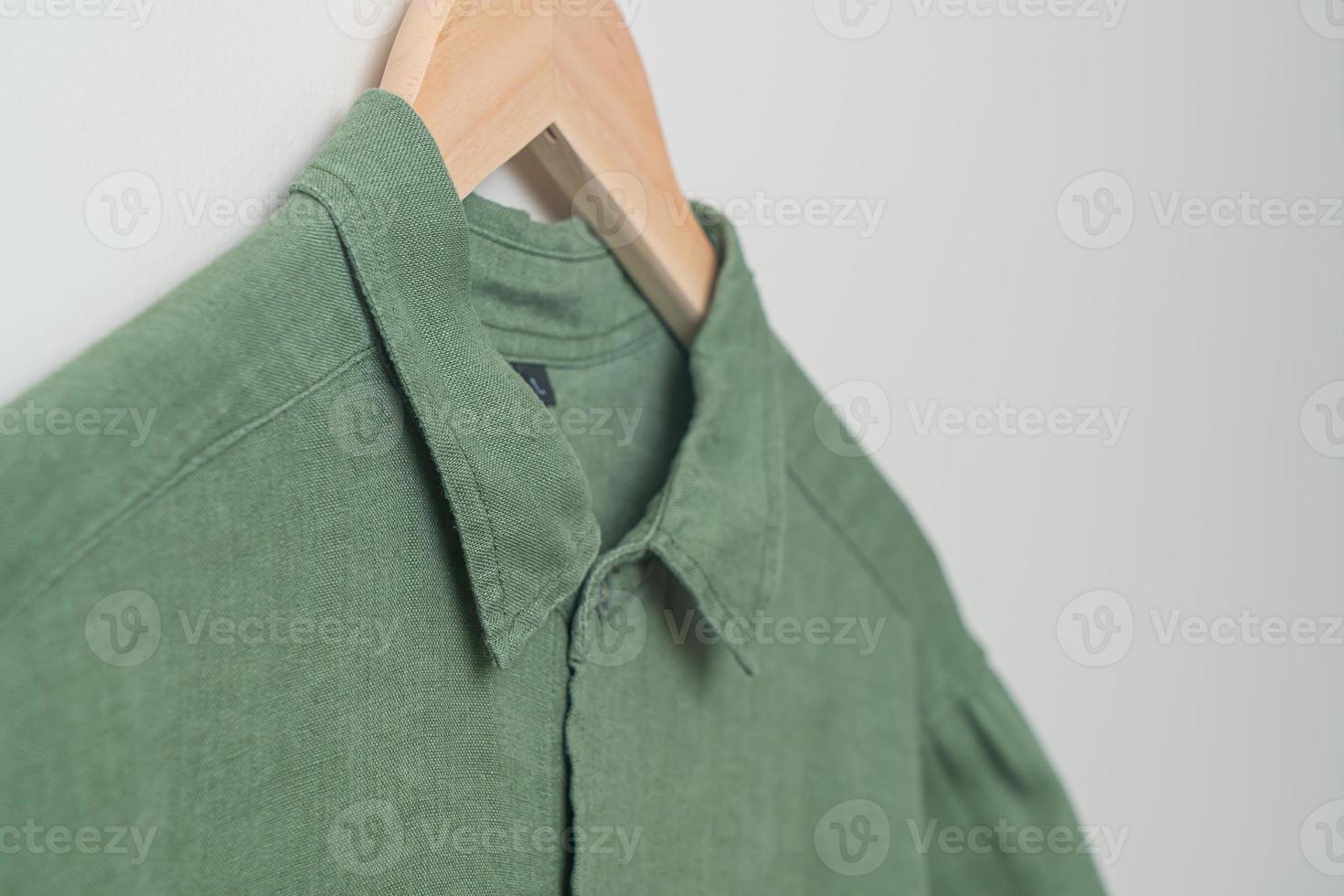 hanging shirt with wood hanger on wall photo