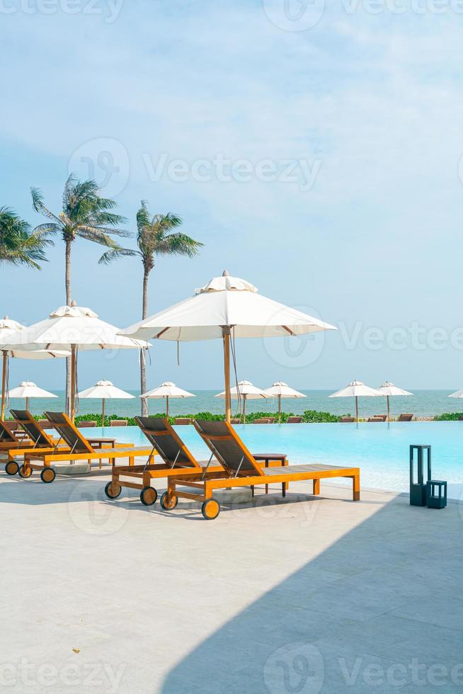 umbrella with bed pool around swimming pool with ocean sea background photo