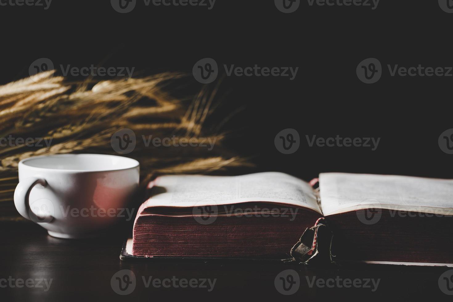 Holy bible book with paper for education on black wooden background. Christian catholic with protestant worship and pray in church. Concept of learning about faith god and religion, jesus spiritual. photo