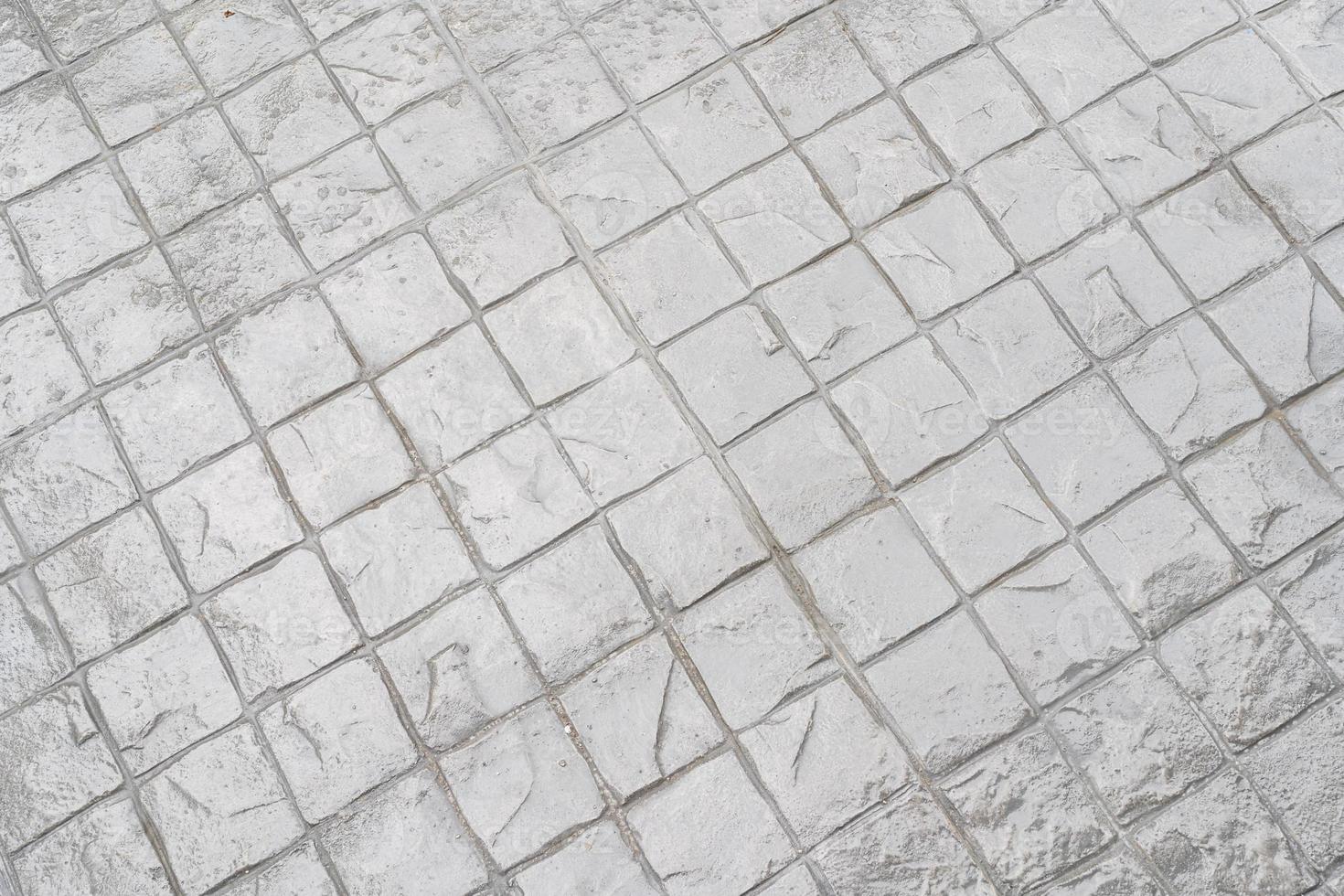 Granite cobblestoned pavement background. Stone pavement texture. Abstract background of cobblestone pavement. Rough textured surface of large gray paving slabs photo
