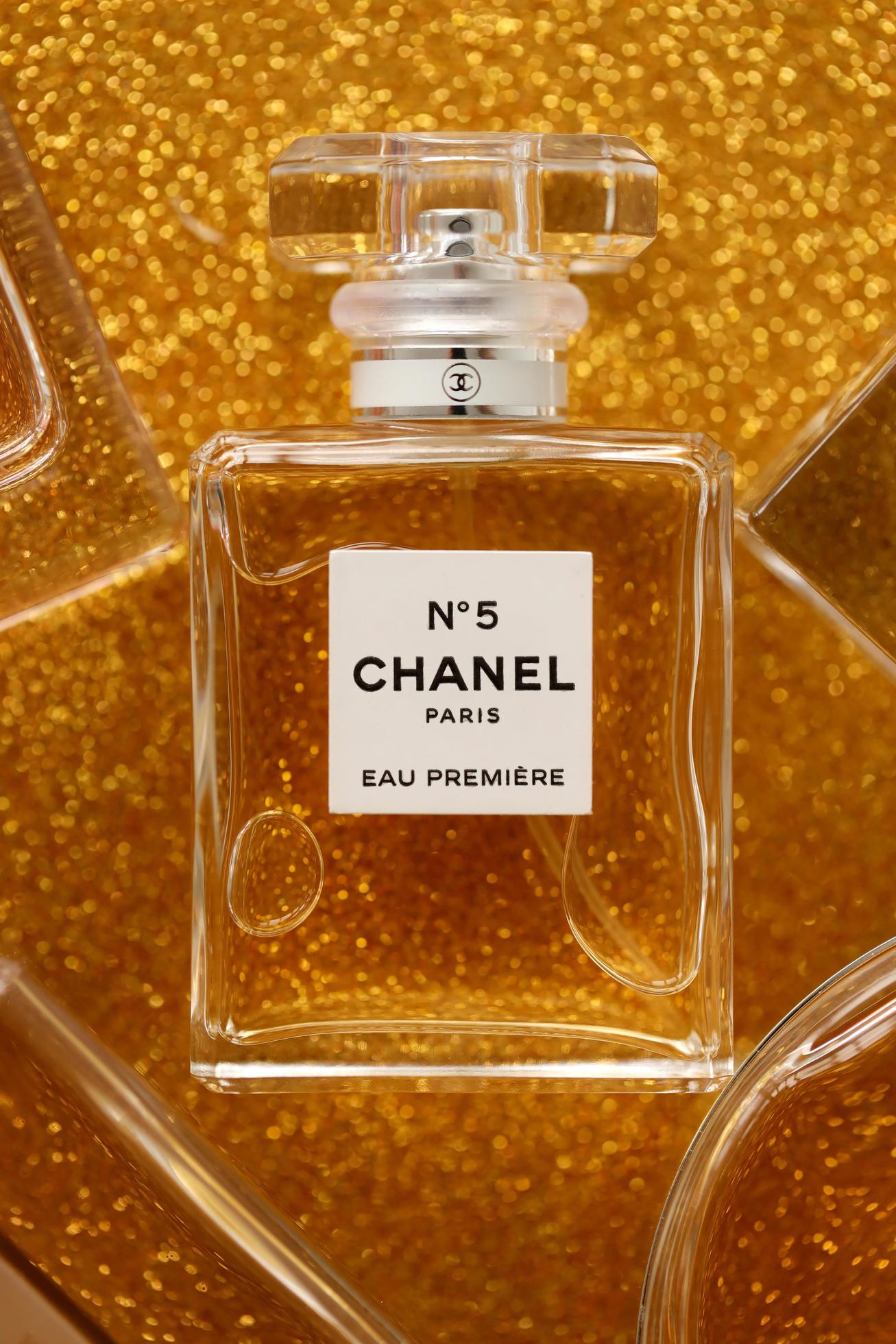 TERNOPIL, UKRAINE - SEPTEMBER 2, 2022 Chanel Number 5 Eau Premiere  worldwide famous french perfume bottle among other perfumes on shiny  glitter background in yellow colors 12345884 Stock Photo at Vecteezy