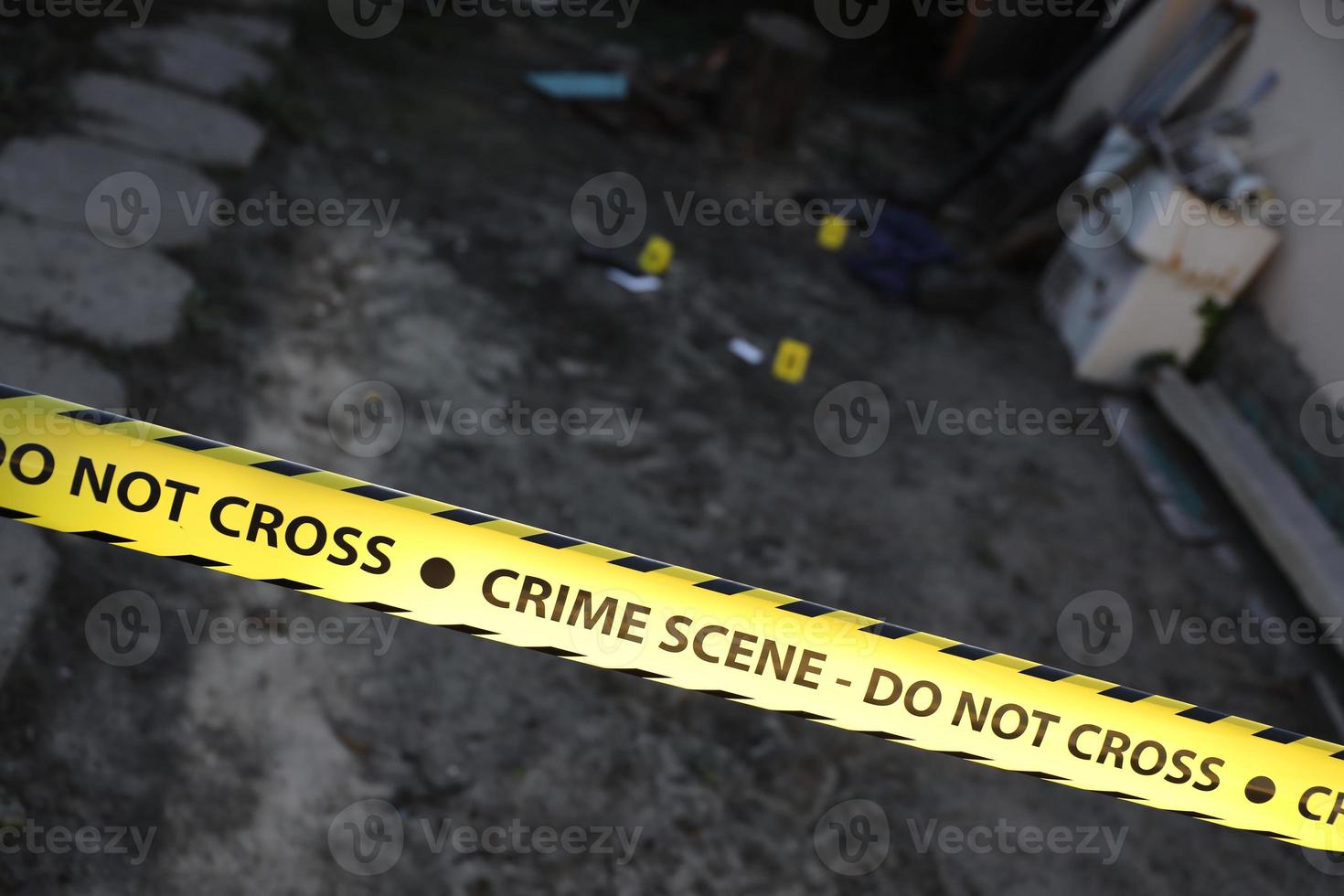 Crime scene tape for covering the area cordon. Yellow tape with blurred forensic law enforcement background in cinematic tone photo