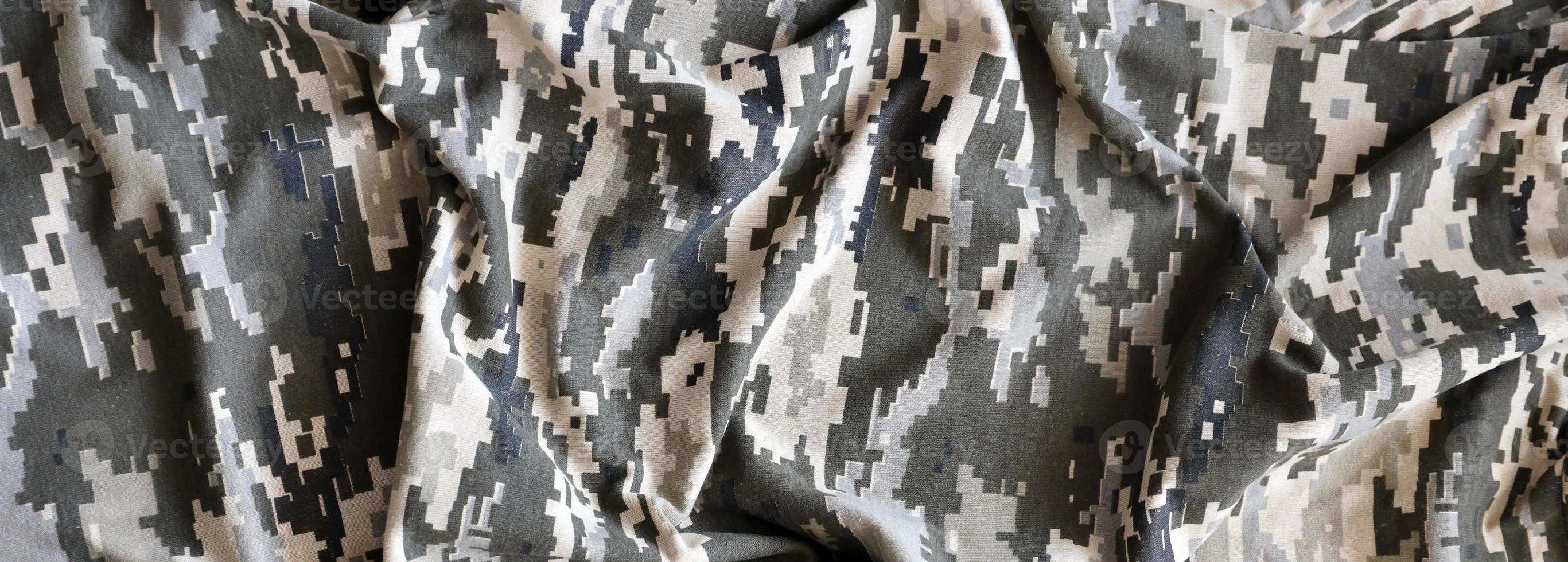 Fabric with texture of Ukrainian military pixeled camouflage. Cloth with camo pattern in grey, brown and green pixel shapes. Official uniform of Ukrainian soldiers photo