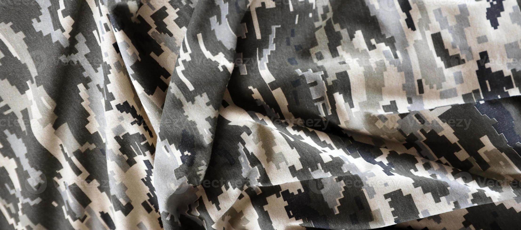 Fabric with texture of Ukrainian military pixeled camouflage. Cloth with camo pattern in grey, brown and green pixel shapes. Official uniform of Ukrainian soldiers photo