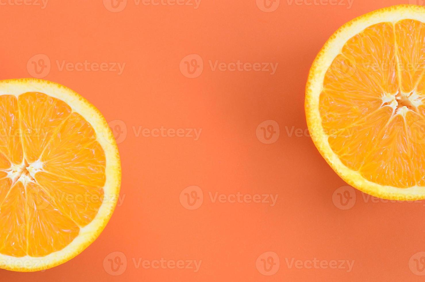 Top view of a several orange fruit slices on bright background in orange color. A saturated citrus texture image photo