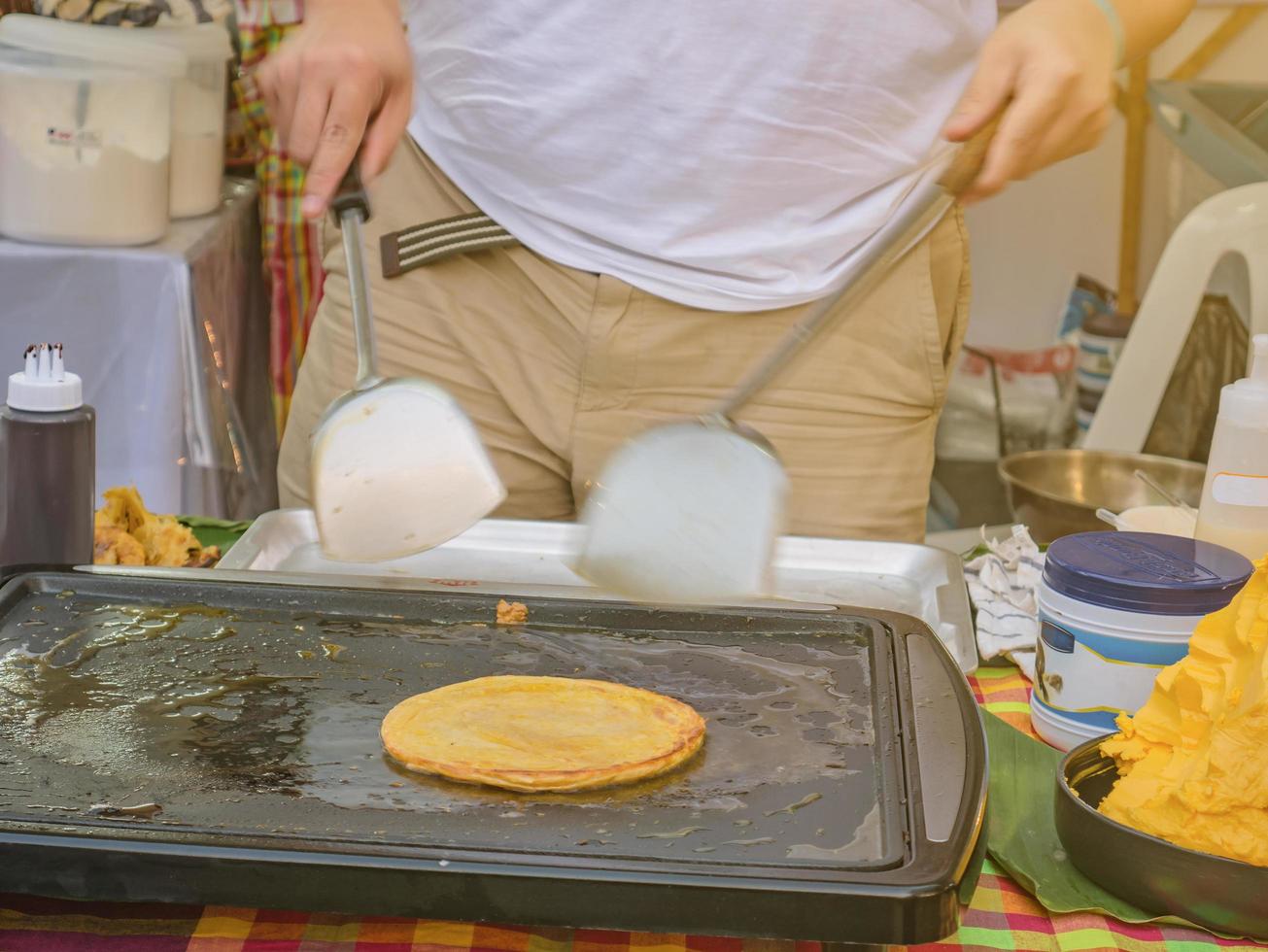 cocinar roti en el puesto de comida del bazar en la calle foto