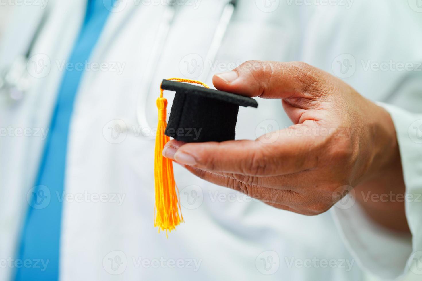 Asian woman doctor holding graduation hat in hospital, Medical education concept. photo