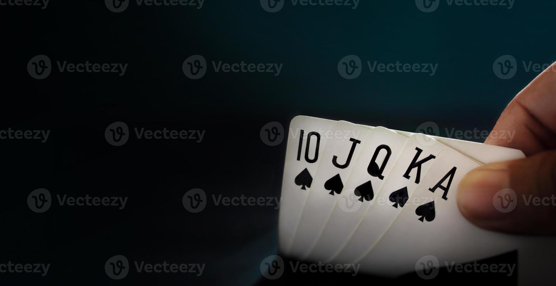 Royal State Flush Playing Card. Player Opening  a Poker Card. Closeup and Dark Tone photo