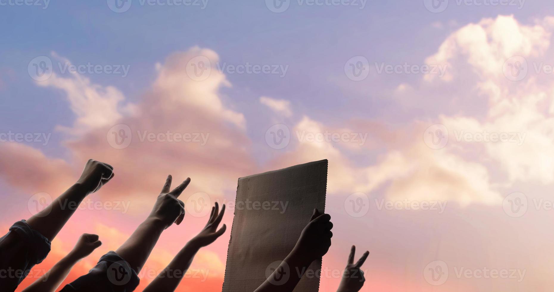 concepto de protesta, mafia, expresión y huelga. la silueta de la gente levanta las manos hacia el cielo. el líder sosteniendo un papel corrugado. foto