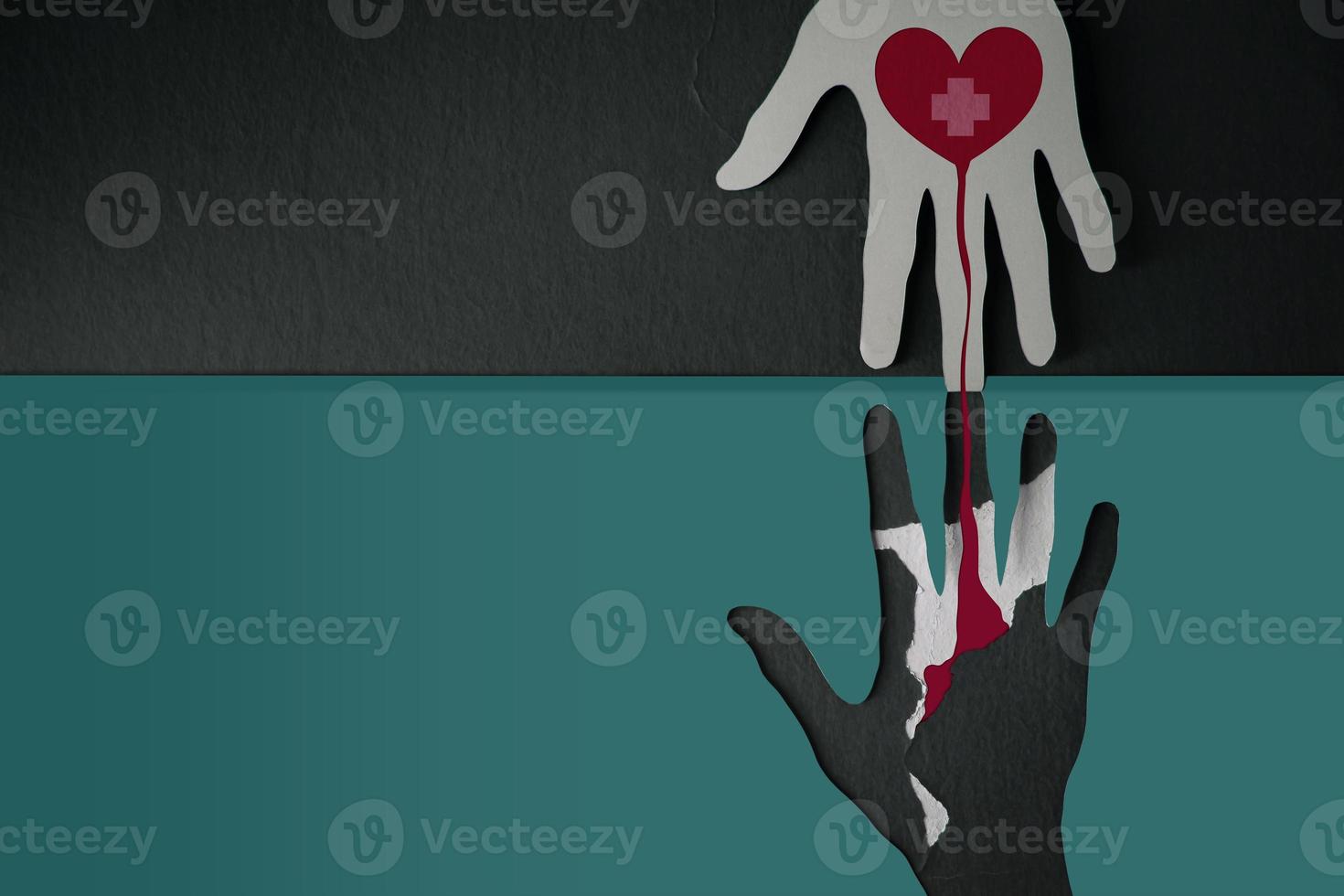 Blood Donation Concept. Help, Care, Love, Support. Paper Cut as Hand Shape hanging on the wall. look like the top one with a Red Heart and Cross Giving Blood to the one below photo