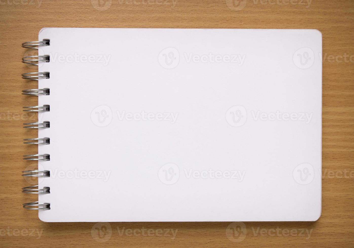 blank white spiral notebook on wood background photo