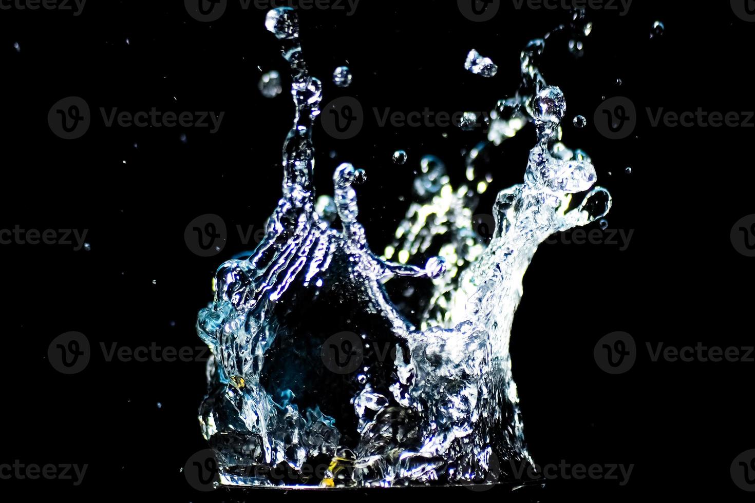 Splashing water on a black background. water droplets scattered on a black background photo