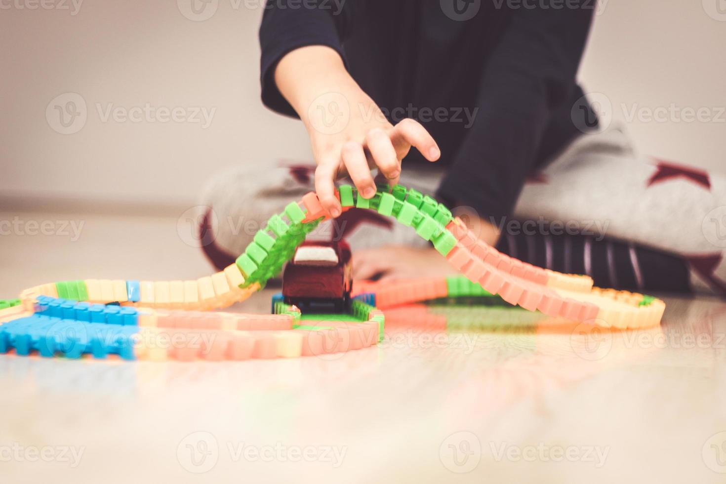 Close up of boy playing with toy cars on the floor. photo