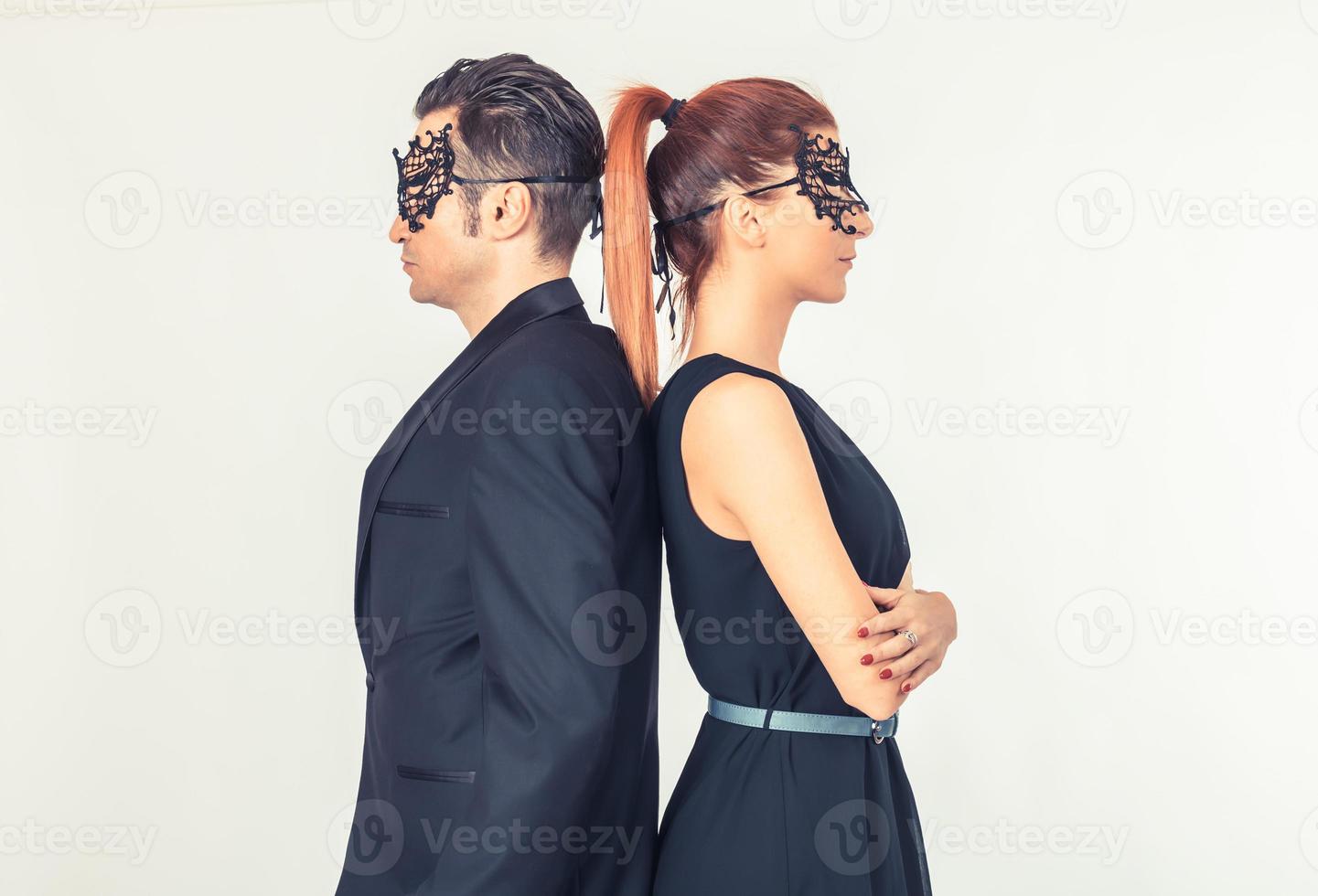Couple with masks on faces standing back to back. photo