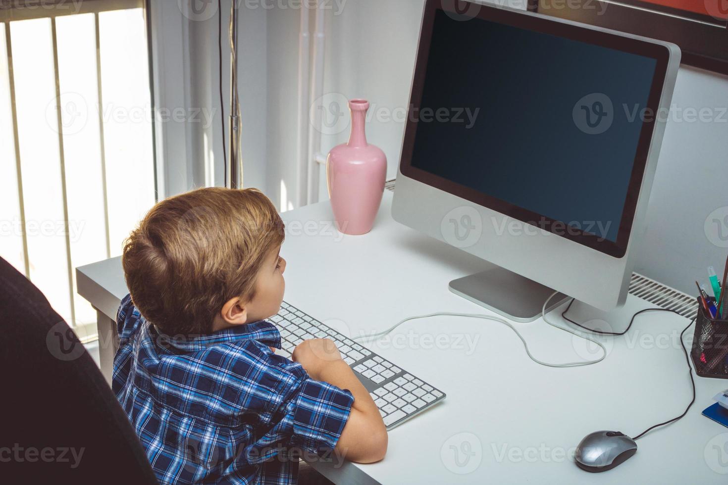 niño pequeño usando computadora en casa. foto