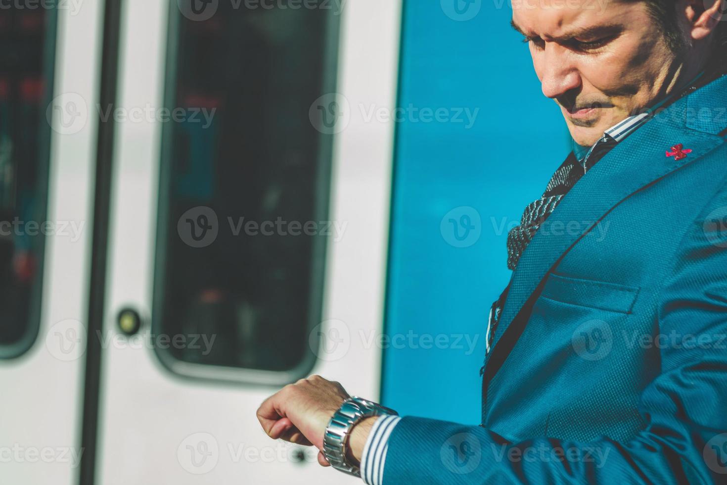 Serious businessman checking time on his wristwatch. photo