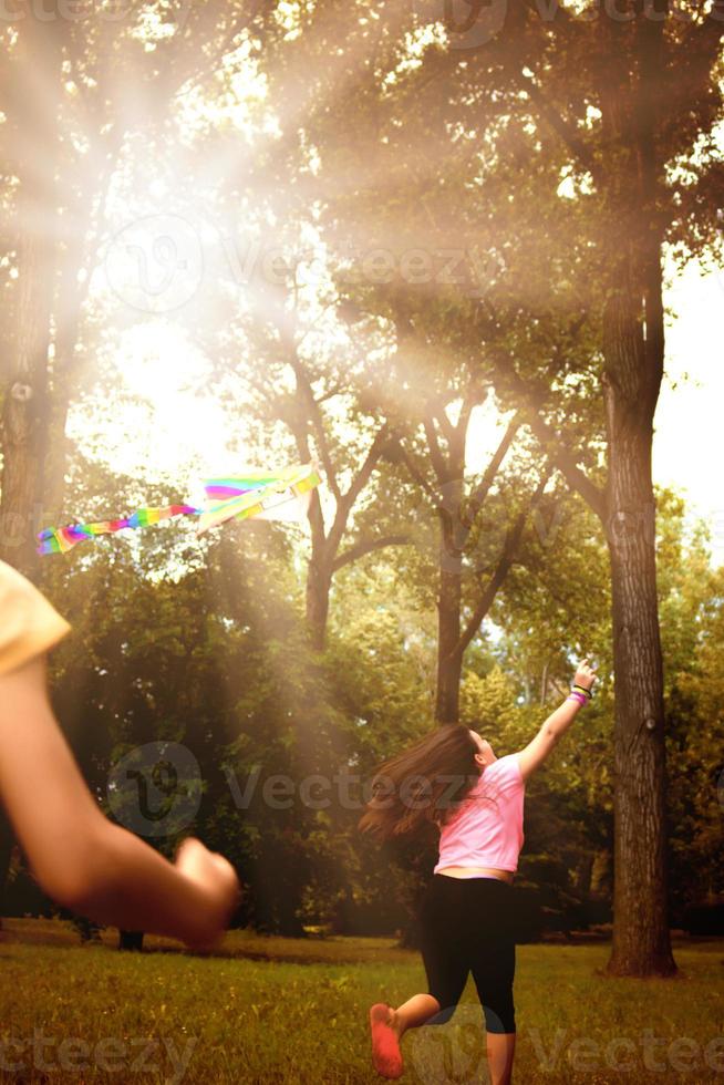 Back view of girl flying a kite in nature. photo