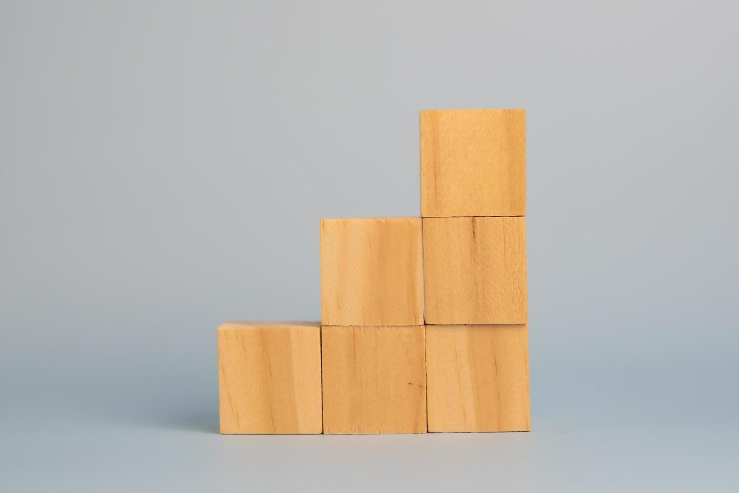 mano que sostiene el bloque de madera del cubo en blanco en el fondo. copie el espacio foto