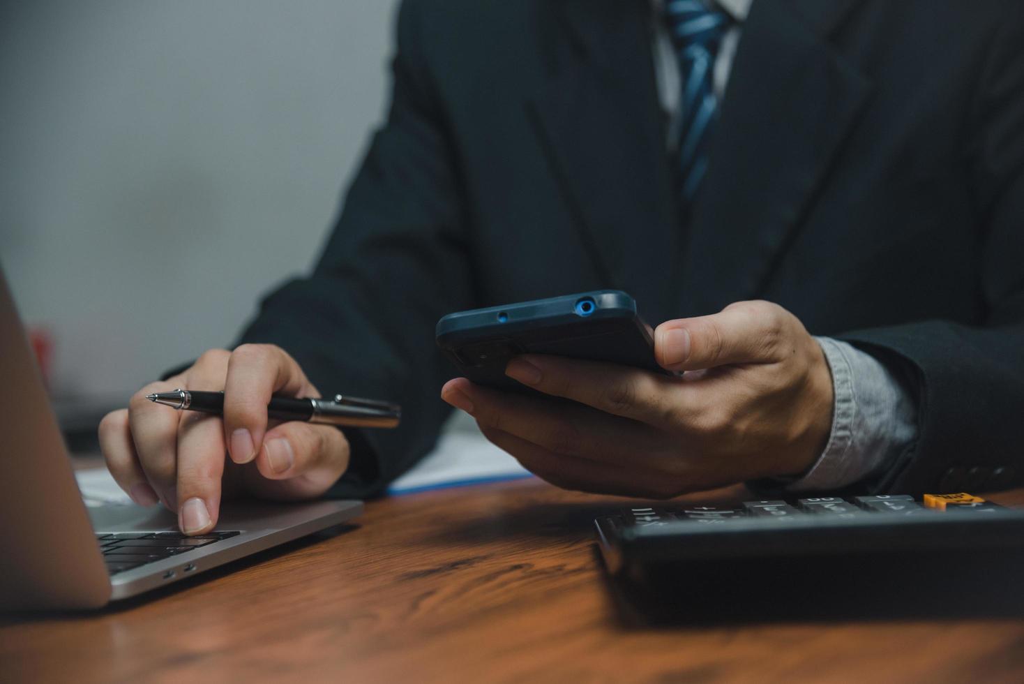 Businessman using smartphone marketing laptop computer business network manager. man using notebook internet online technology communication. photo