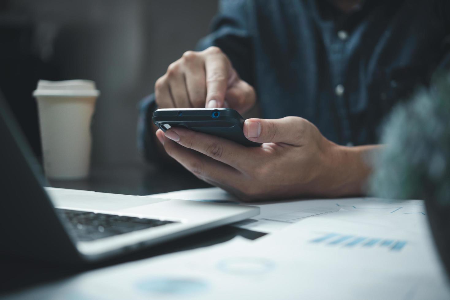 Businessman using smartphone marketing laptop computer business network manager. man using notebook internet online technology communication. photo