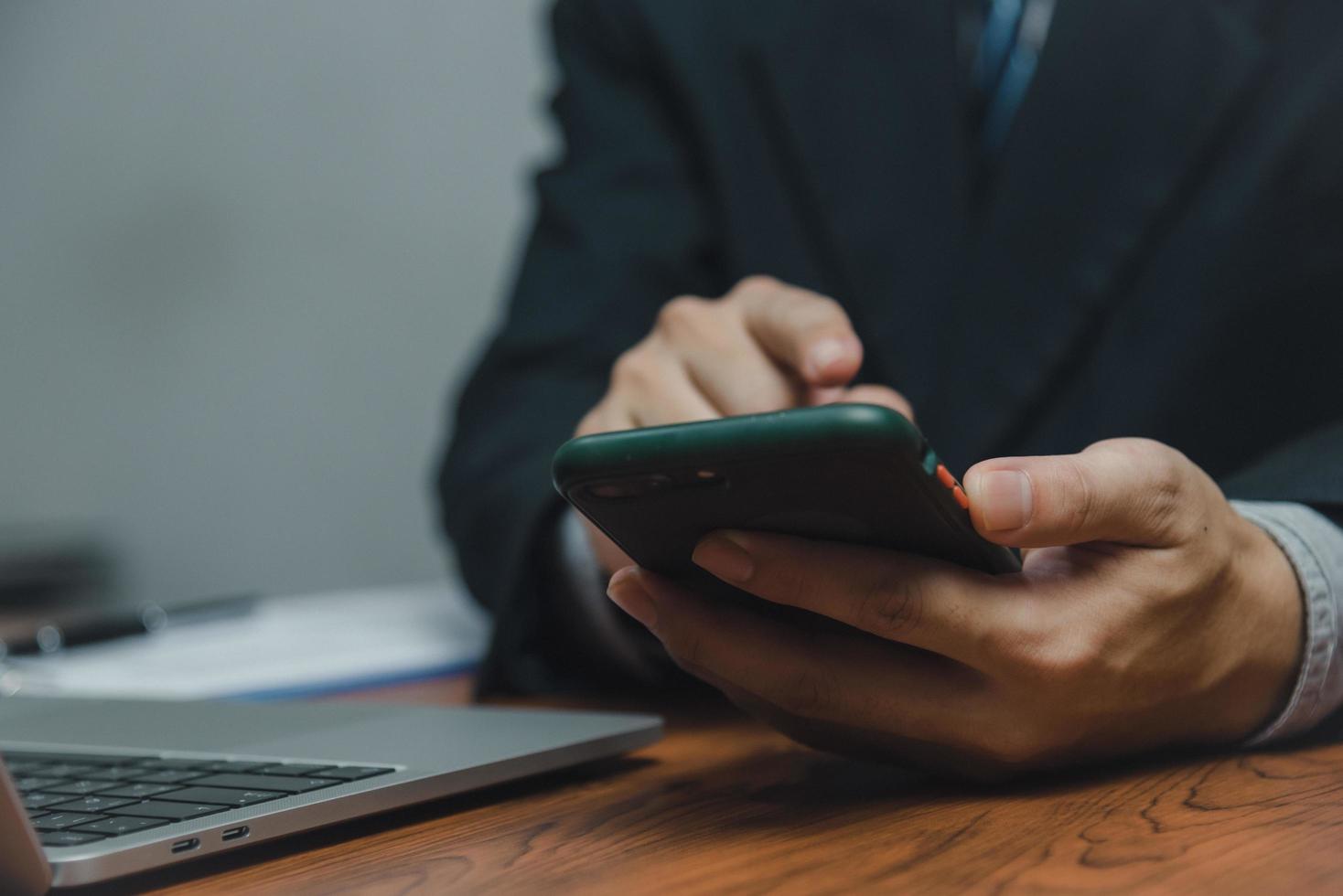 Businessman using smartphone marketing laptop computer business network manager. man using notebook internet online technology communication. photo