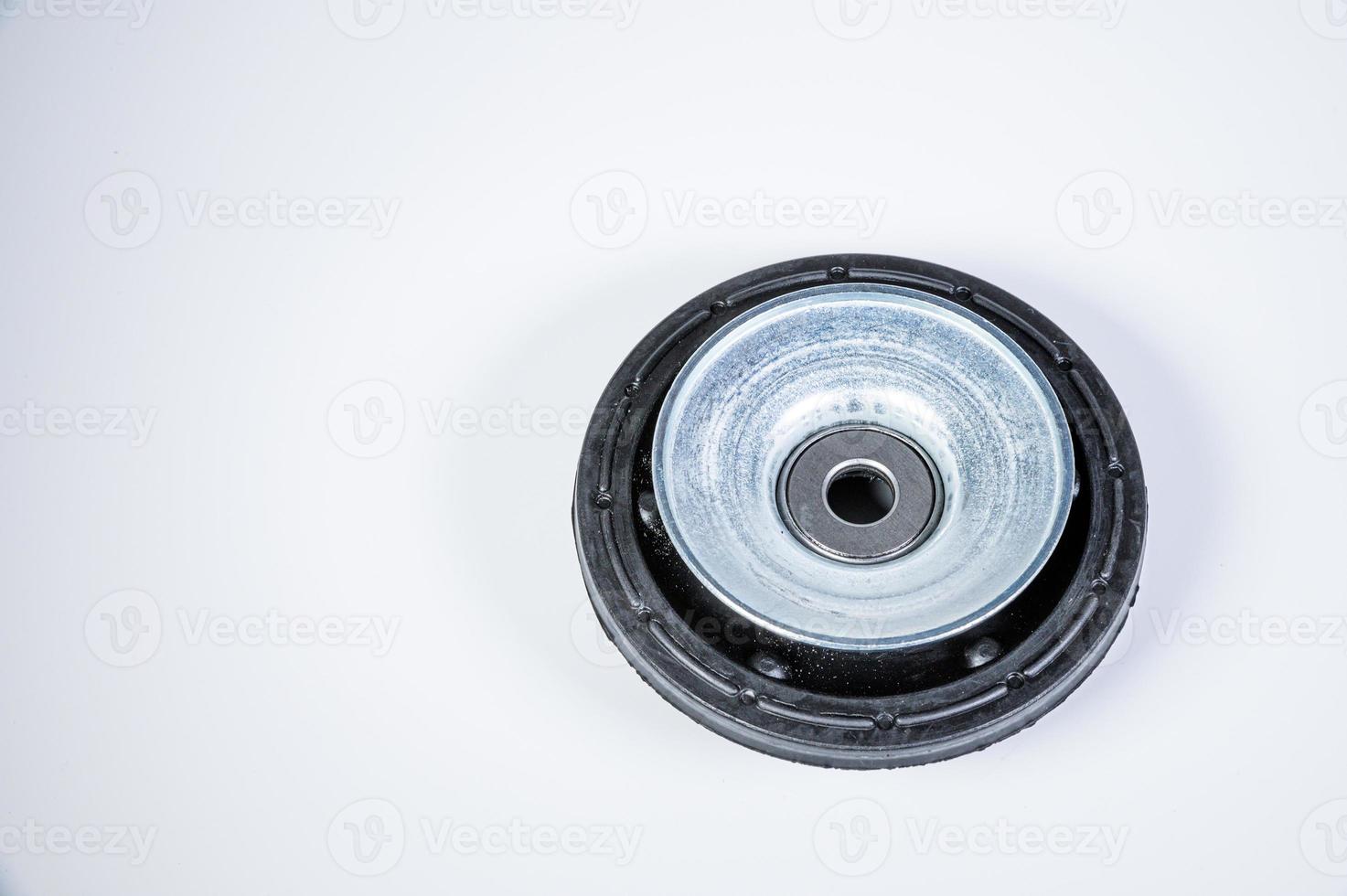 New thrust bearing of front suspension strut of a car on a gray background. The concept of new spare parts and replacement parts in service centers photo