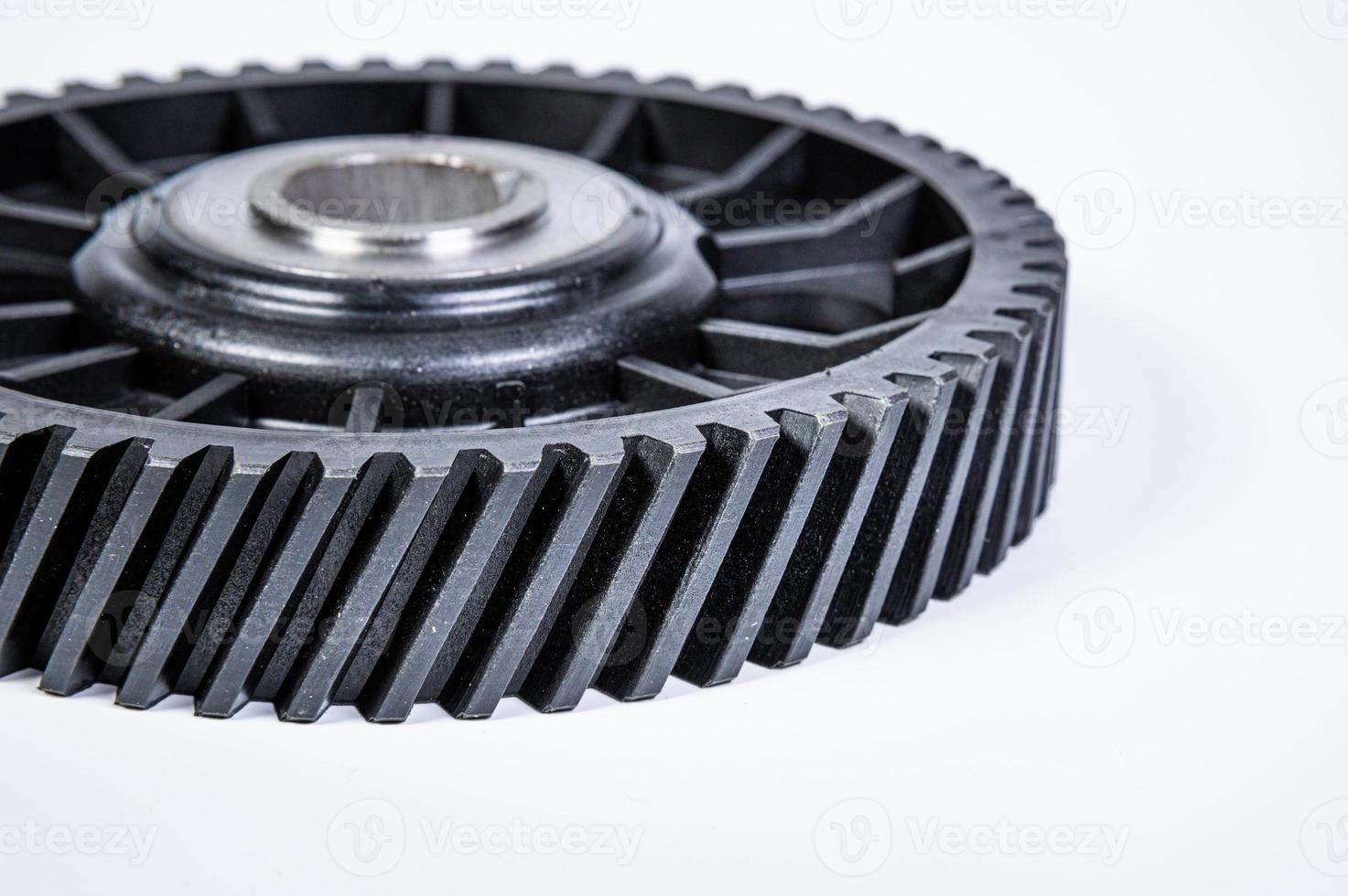 Black polymer gear camshaft with metal base. New spare part for an internal combustion engine on a gray background photo