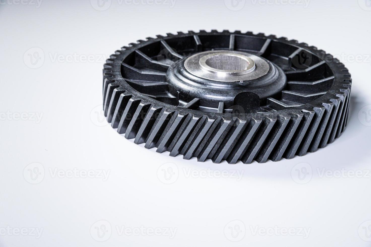 Black polymer gear camshaft with metal base. New spare part for an internal combustion engine on a gray background photo