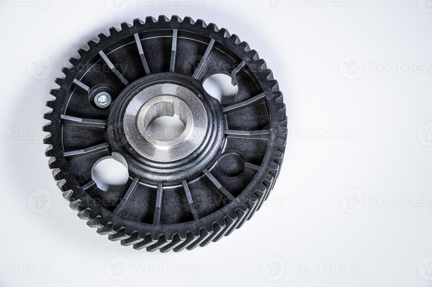 Black polymer gear camshaft with metal base. New spare part for an internal combustion engine on a gray background photo