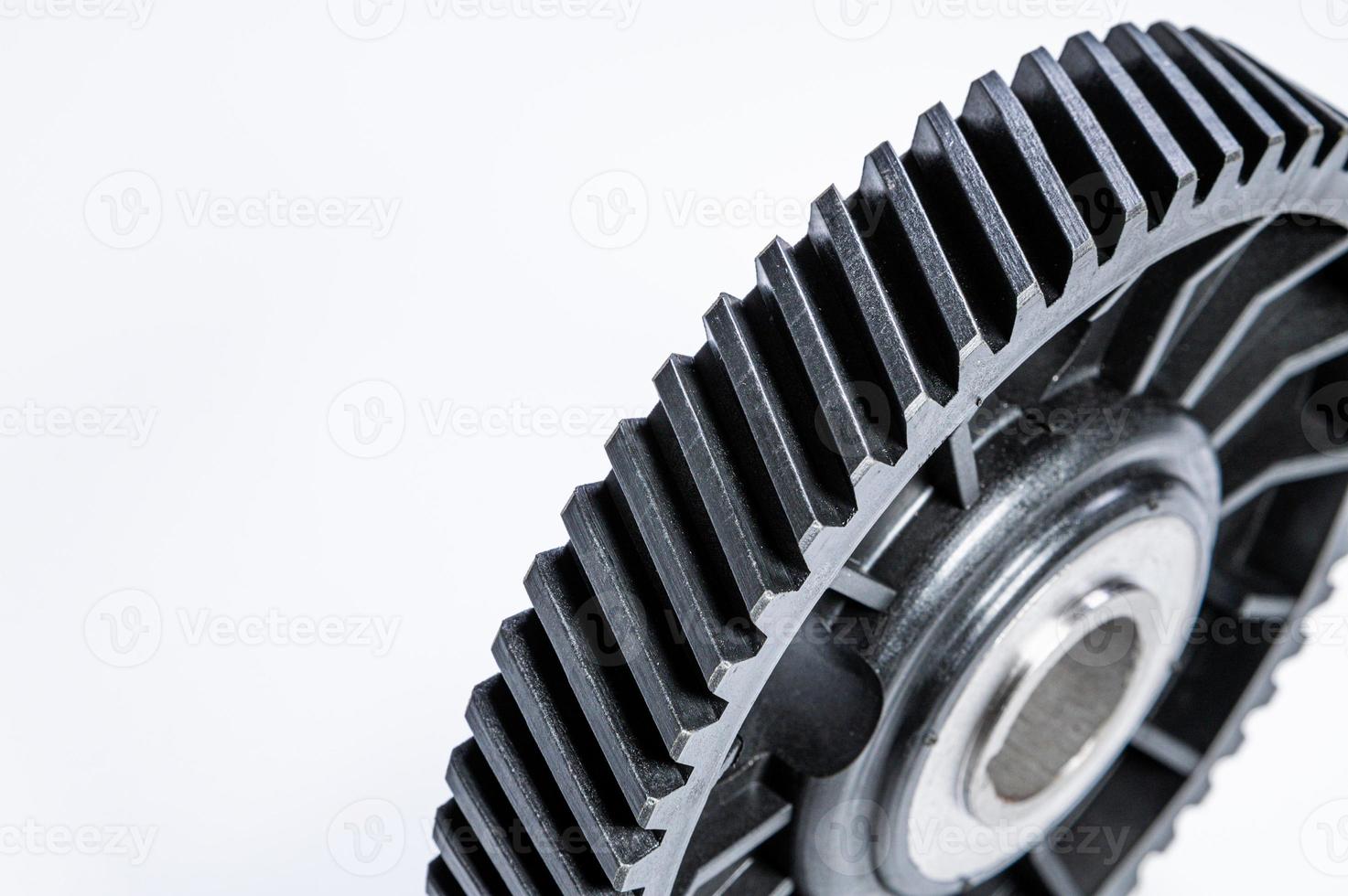 Black polymer gear camshaft with metal base. New spare part for an internal combustion engine on a gray background photo