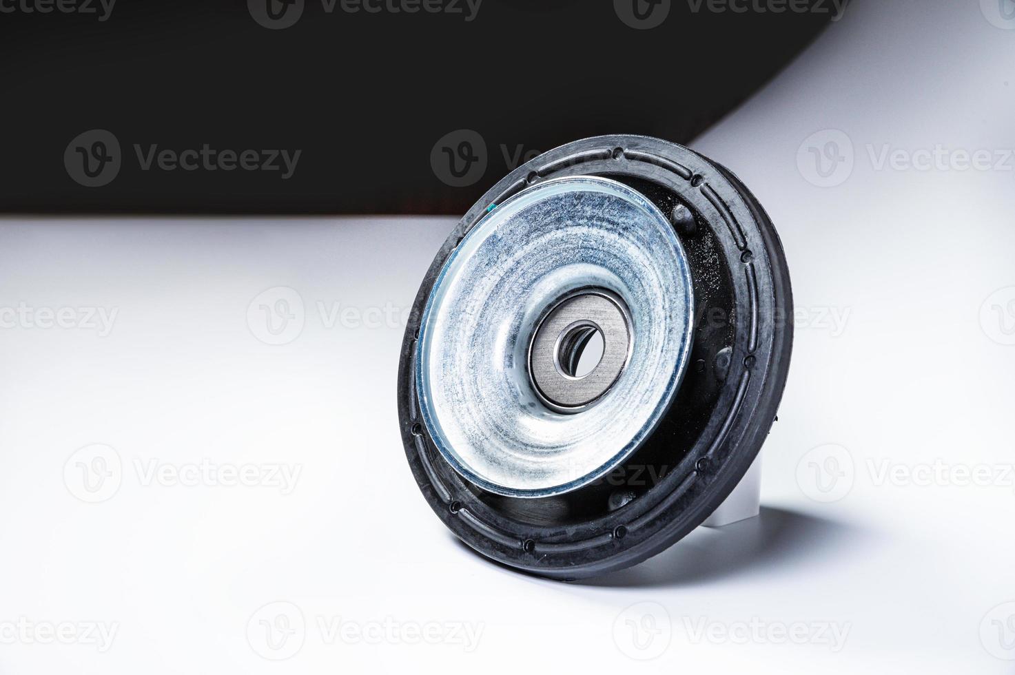 New thrust bearing of front suspension strut of a car on a gray background. The concept of new spare parts and replacement parts in service centers photo