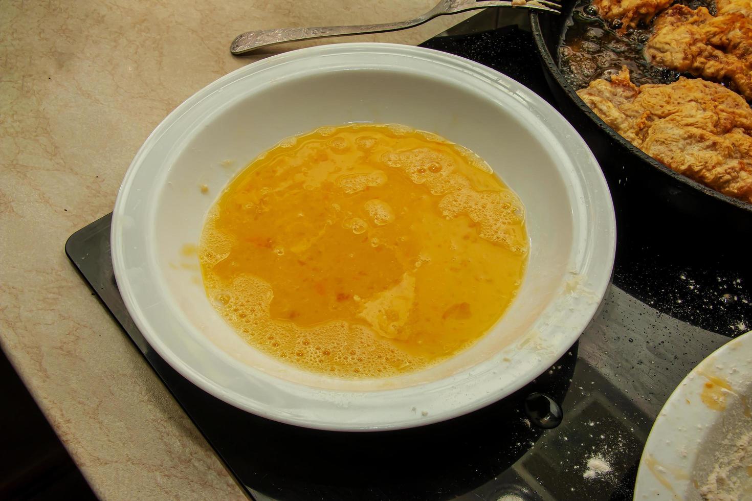 Beef chop batter in a plate on the stove. The process of making batter beef chops photo
