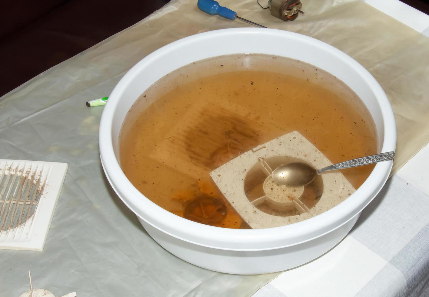 Washing the plastic parts of a very dirty kitchen exhaust fan in an aqueous solution of sodium hydroxide photo