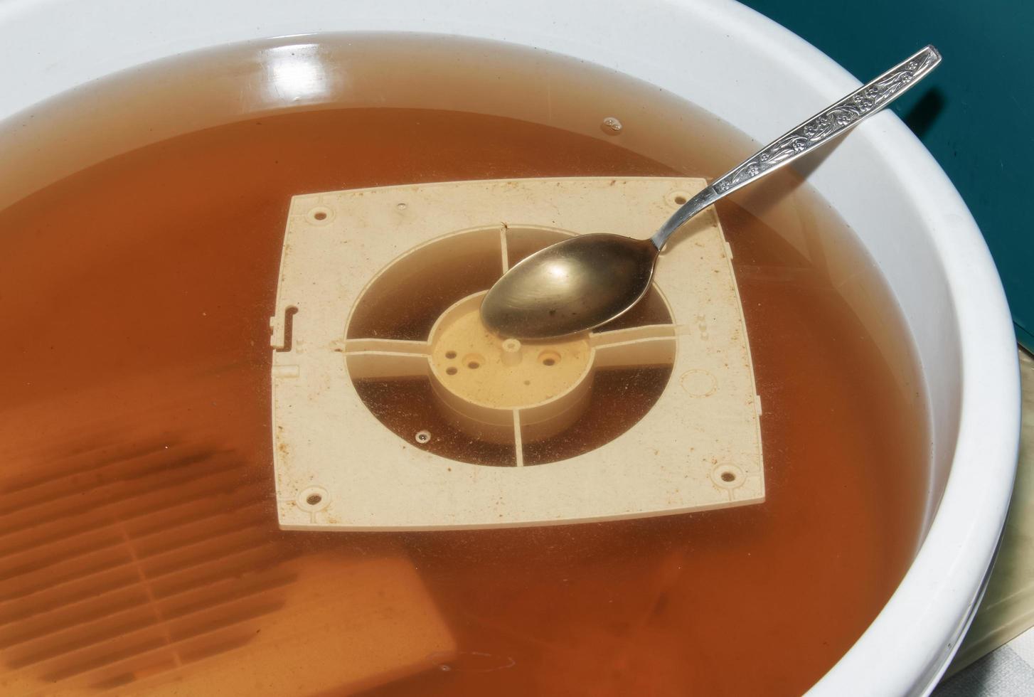 Washing the plastic parts of a very dirty kitchen exhaust fan in an aqueous solution of sodium hydroxide photo
