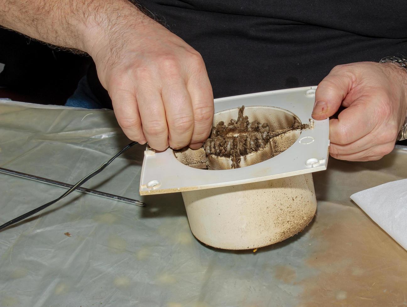 primer plano de un extractor de cocina muy sucio. ventilador antes de la limpieza y el lavado preventivos. proceso de desmontaje foto