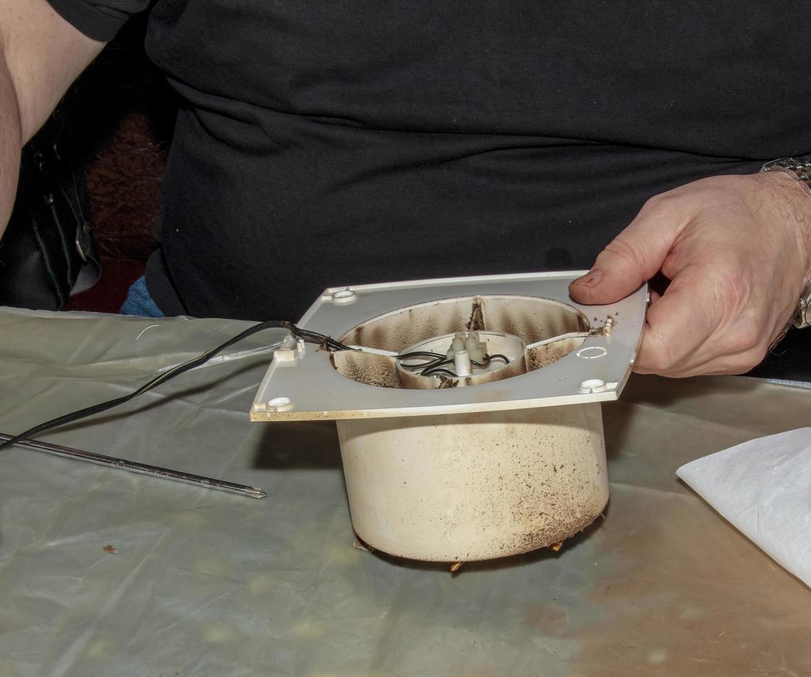 primer plano de un extractor de cocina muy sucio. ventilador antes de la limpieza y el lavado preventivos. proceso de desmontaje foto