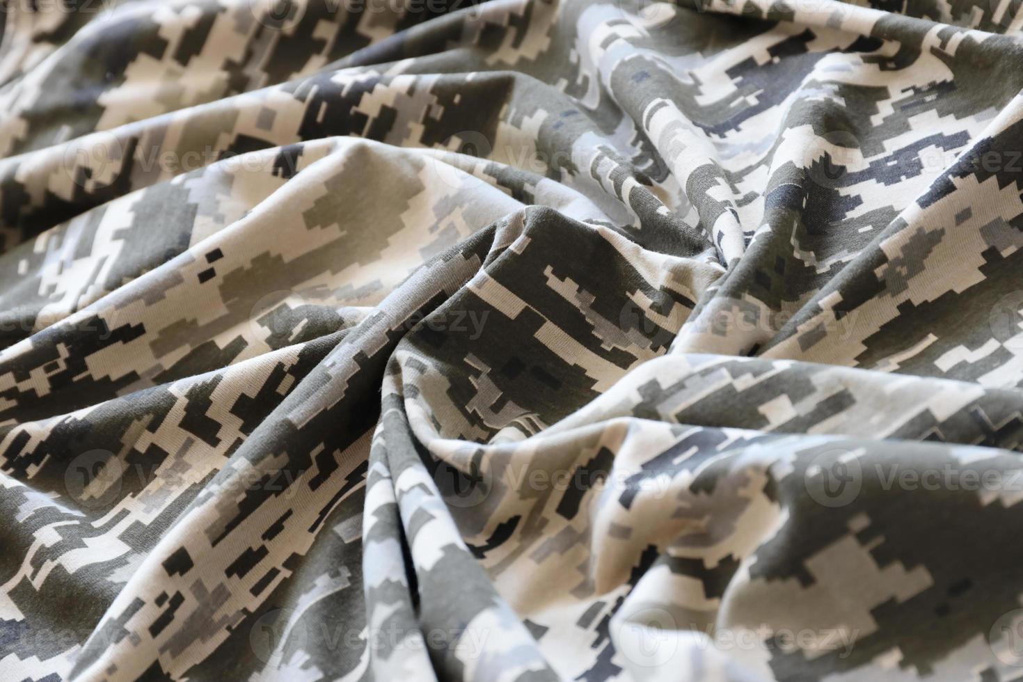 Fabric with texture of Ukrainian military pixeled camouflage. Cloth with camo pattern in grey, brown and green pixel shapes. Official uniform of Ukrainian soldiers photo