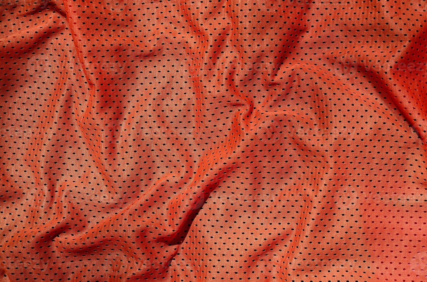 Sport clothing fabric texture background. Top view of red polyester nylon cloth textile surface. Colored basketball shirt with free space for text photo