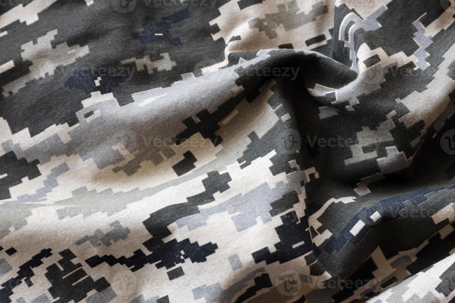 Fabric with texture of Ukrainian military pixeled camouflage. Cloth with camo pattern in grey, brown and green pixel shapes. Official uniform of Ukrainian soldiers photo