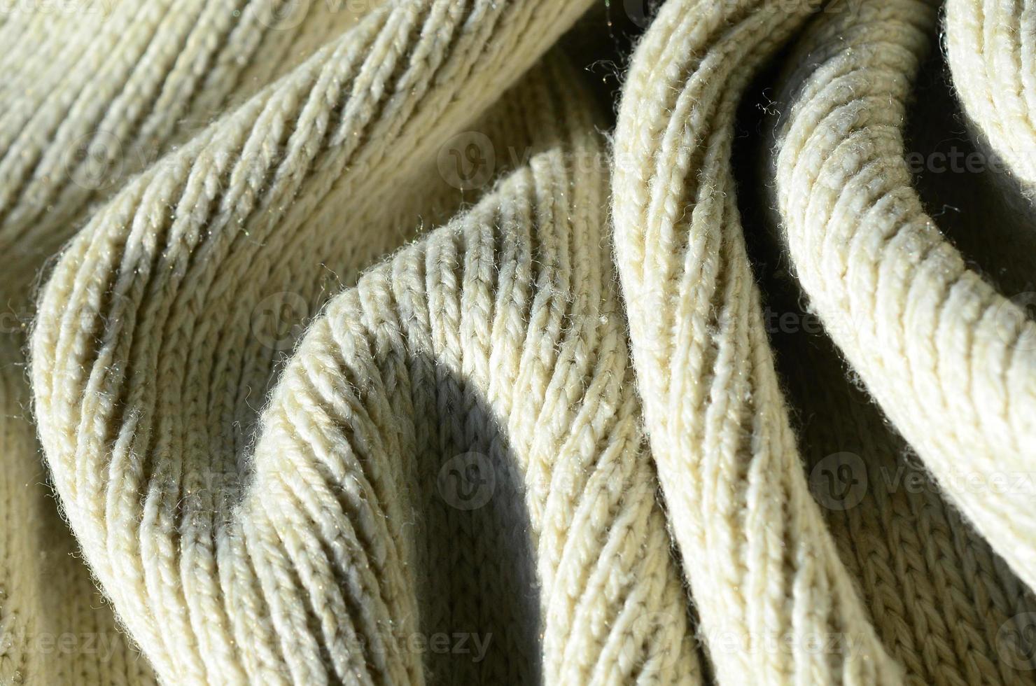 Fabric texture of a soft yellow knitted sweater. Macro image of the structure of bindings in yarns photo