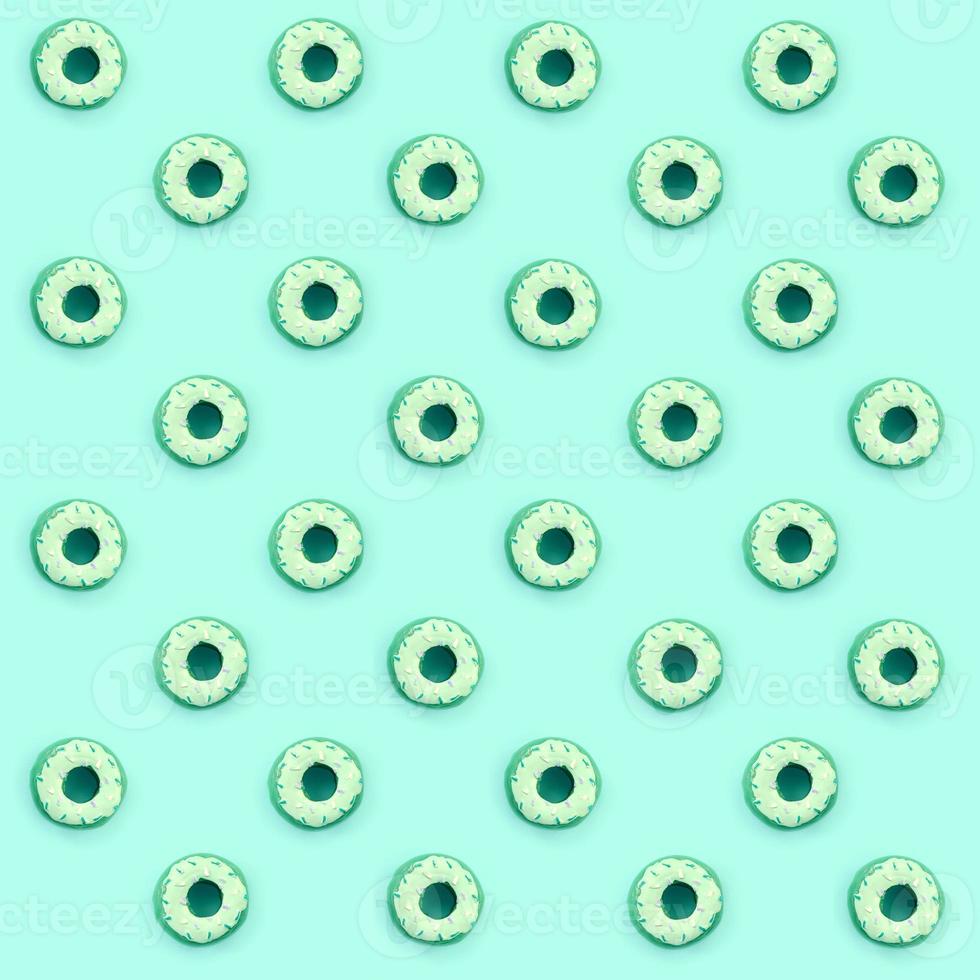 Many small plastic donuts lies on a pastel colorful background. Flat lay minimal pattern. Top view photo