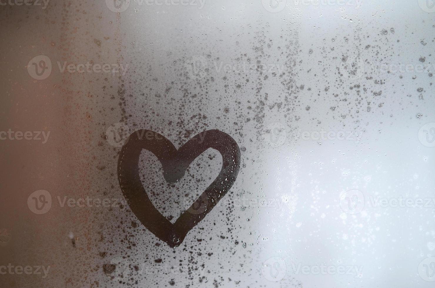 The heart is painted on the misted glass in the winter photo