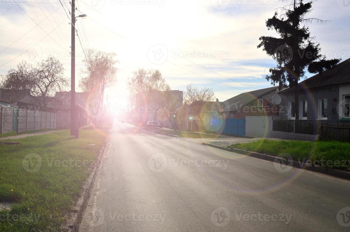 Asphalt road in the middle of a rural landscape in the early summer photo